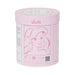 Pink cylindrical container with a face design and 'Lélita' branding on a white background
