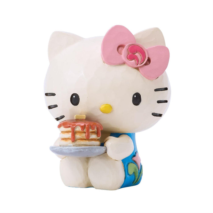 Hello Kitty figurine holding a plate with a pancake on a white background