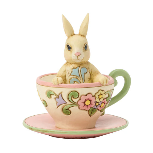 Decorative figurine of a rabbit in a teacup with floral design on a white background