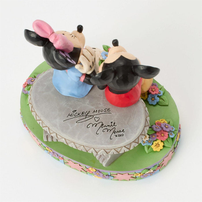 Cake with Mickey and Minnie Mouse figurines on a white background