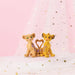 Two lion cubs from 'The Lion King' standing on a pink and white background with star decorations.