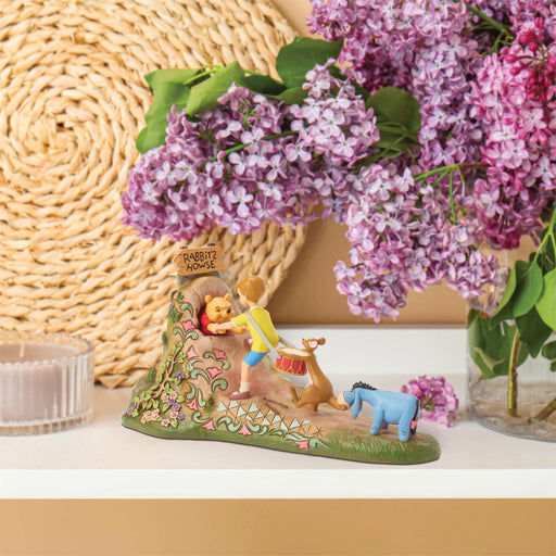 Decorative figurine with characters from 'The Wishing Well' surrounded by purple flowers.