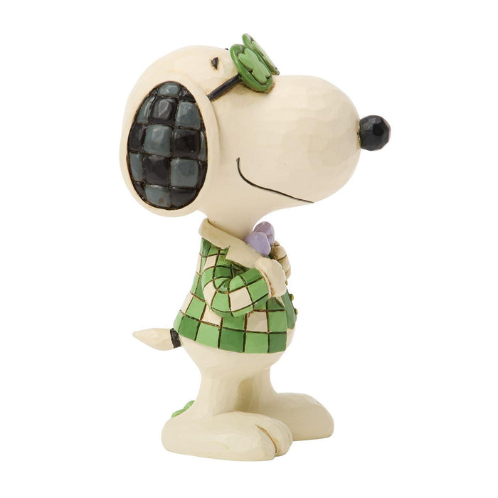 Snoopy figurine wearing a green outfit with a bow tie on a white background
