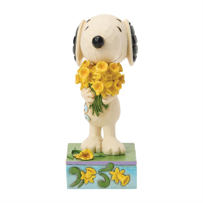 Dog figurine holding yellow flowers on a white background