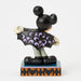 Mickey Mouse figurine in a Halloween costume with a black cape and purple accents on a white background.