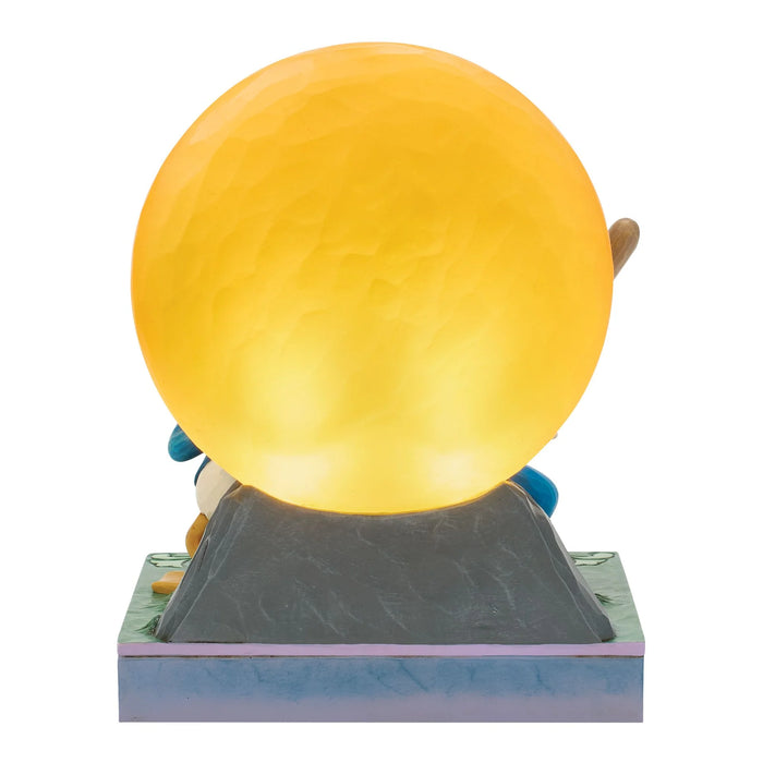 Figurine with a large yellow ball on a white background