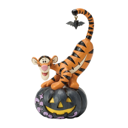 Tigger figurine on a Halloween pumpkin with a bat on a white background