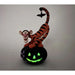 Glowing Halloween-themed figurine of a tiger on a pumpkin with a bat.