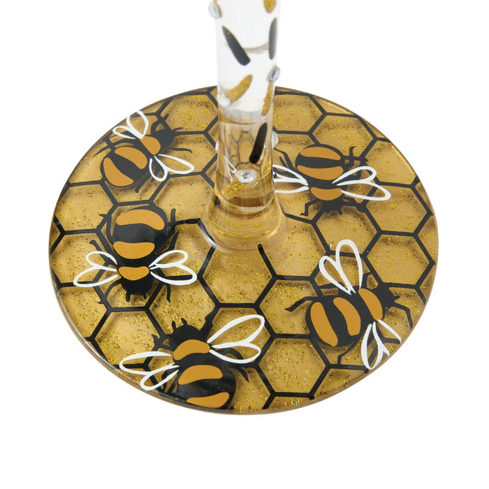 Decorative glass coaster with bee and honeycomb design on a white background