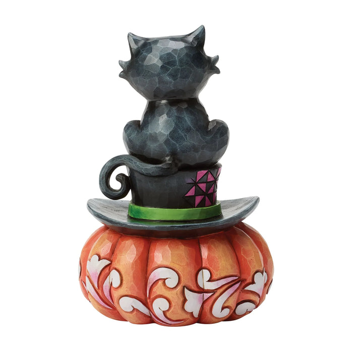 Decorative figurine of a black cat on a pumpkin with geometric design