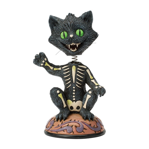 Skeletal black cat figurine with green eyes on a white background