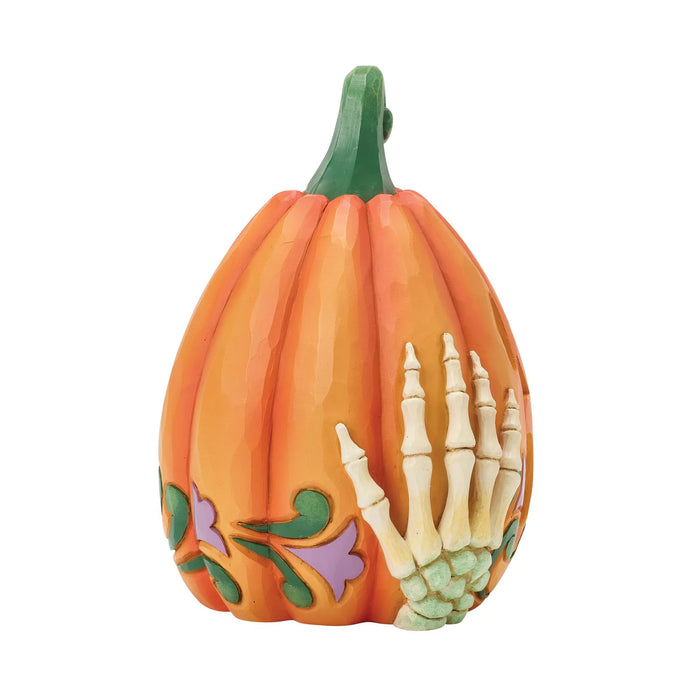 Decorative pumpkin with skeleton hand design on a white background