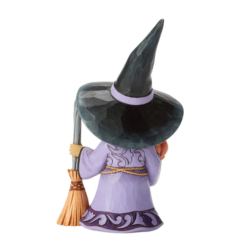 Witch figurine with a broom on a white background