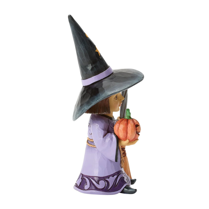 Witch figurine with a pumpkin on a white background