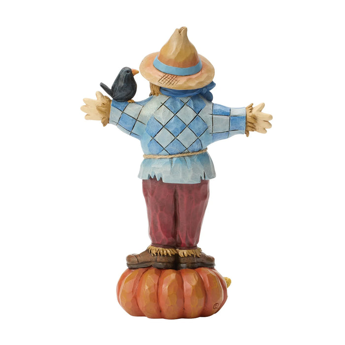Scarecrow figurine with a bird on a white background