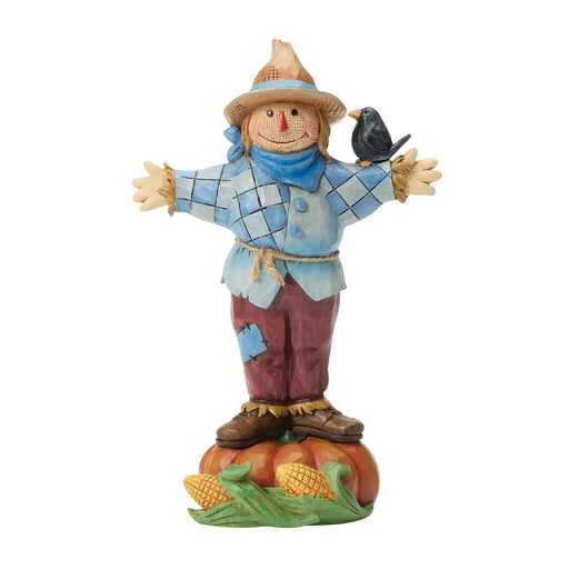 Decorative scarecrow figurine with a bird on a white background