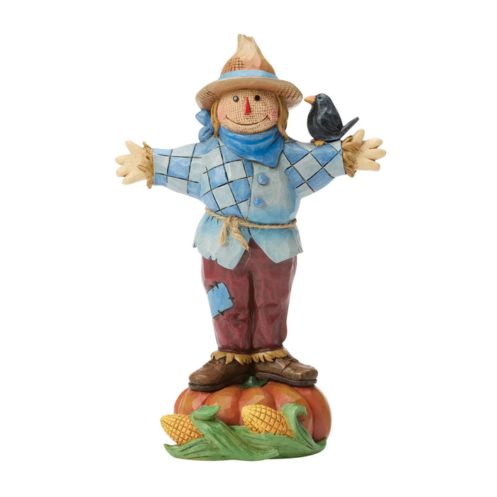 Decorative scarecrow figurine with a bird on a white background