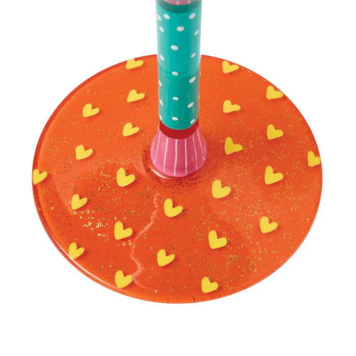 Colorful stand with a red base featuring yellow hearts and a turquoise pole with white polka dots.