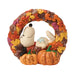 Decorative wreath with autumn leaves, pumpkins, and a small dog figure on a white background