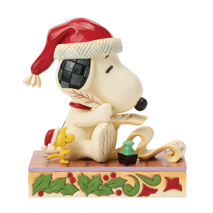 Snoopy figurine wearing a Santa hat with Woodstock next to him on a decorative base.