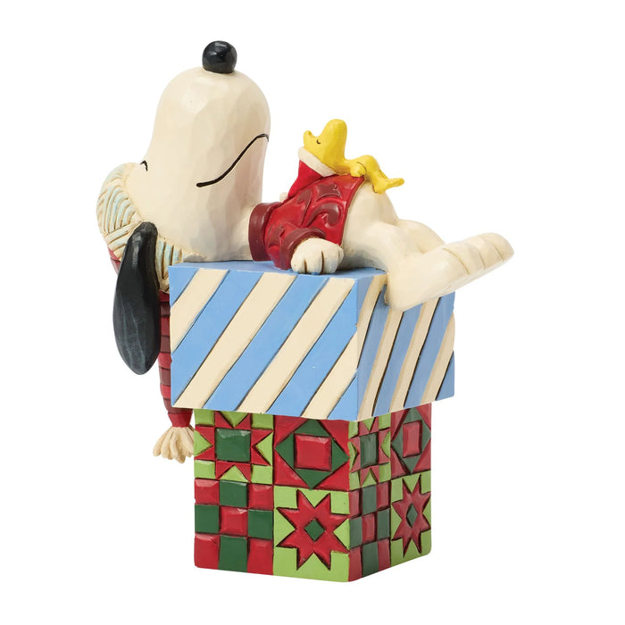 Snoopy figurine with Woodstock on a colorful box against a white background
