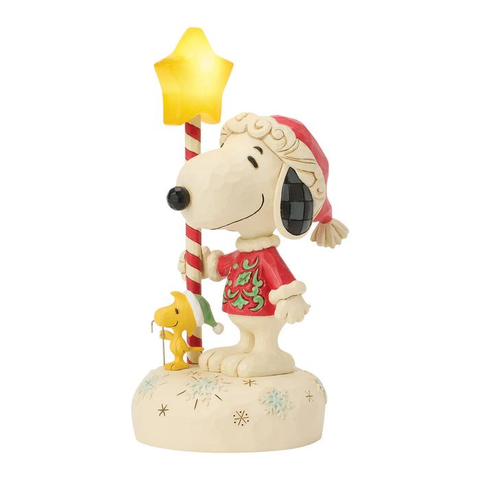 Snoopy figurine holding a candy cane and star on a white background