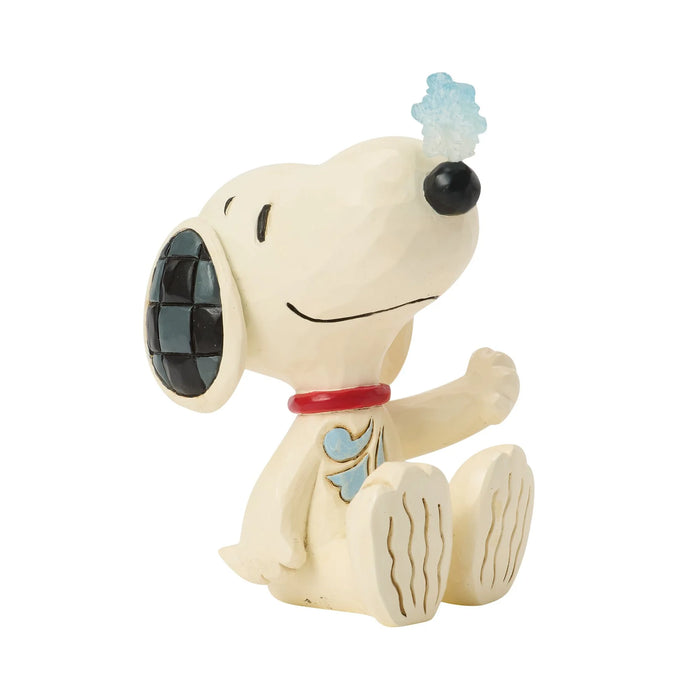 Snoopy figurine with snowflake on his nose on a white background