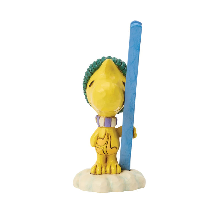 A collectible figurine of a yellow cartoon bird character with a green hat, holding tall blue skis, standing on a small white cloud base against a plain white background.