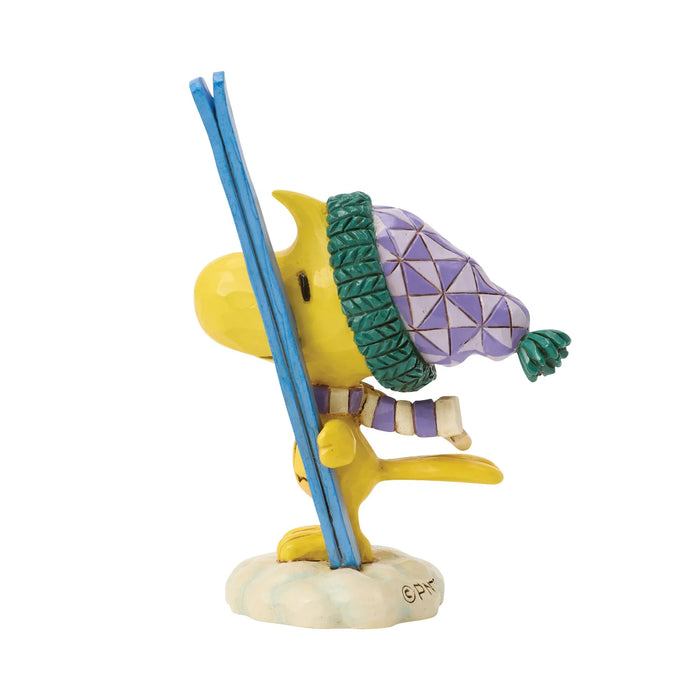 Colorful figurine of a character with a geometric-patterned hat and blue ski poles on a white background