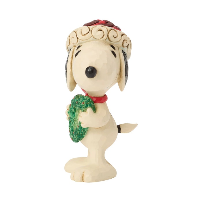 Snoopy figurine holding a heart-shaped wreath in a Santa hat