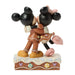 Figurine of a gingerbread man and mouse hugging on a white background