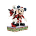 Christmas-themed figurine of a dog and a mouse in festive attire on a decorative base.