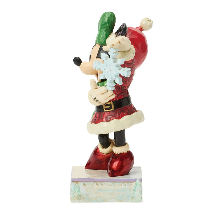 Figurine of a character in a Santa outfit holding a snowflake and green item on a white background