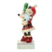 Figurine of a character in a Santa outfit holding a snowflake and green item on a white background