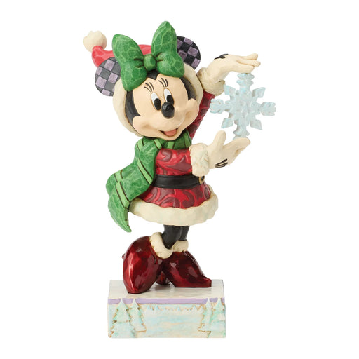 Animated character figurine in festive attire holding a snowflake on a white background