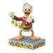 Animated character figurine wearing a festive sweater with bells, on a decorative base.