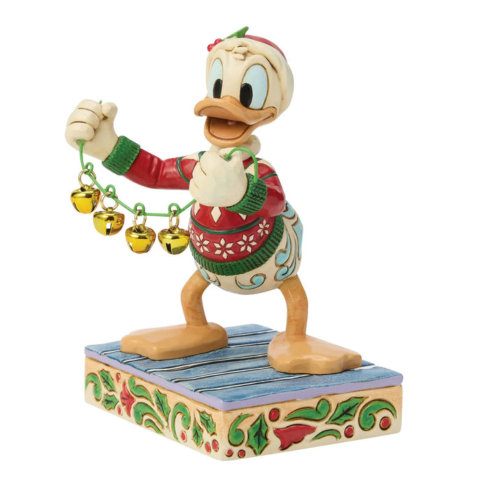 Colorful figurine of a cartoon character holding bells on a decorative base.