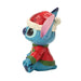 Toy figure of a blue character wearing a Santa hat and red outfit on a white background