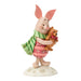 Figurine of a piglet holding a teddy bear on a white background