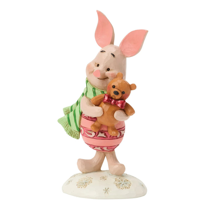 Figurine of a piglet holding a teddy bear on a white background
