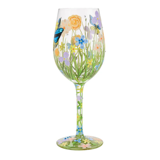 Decorative wine glass with floral and butterfly design on a white background