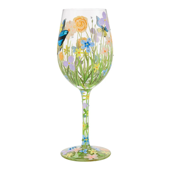 Decorative wine glass with floral and butterfly design on a white background