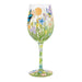 Decorative wine glass with floral and butterfly design on a white background