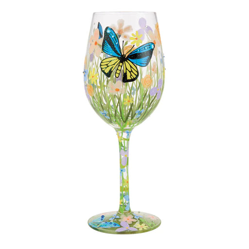 Wine glass with butterfly and floral design on a white background