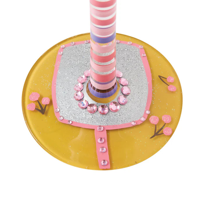 Decorative item with pink and purple striped pole on a yellow base with pink flowers and embellishments.