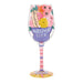 Decorative wine glass with floral design and text on a white background