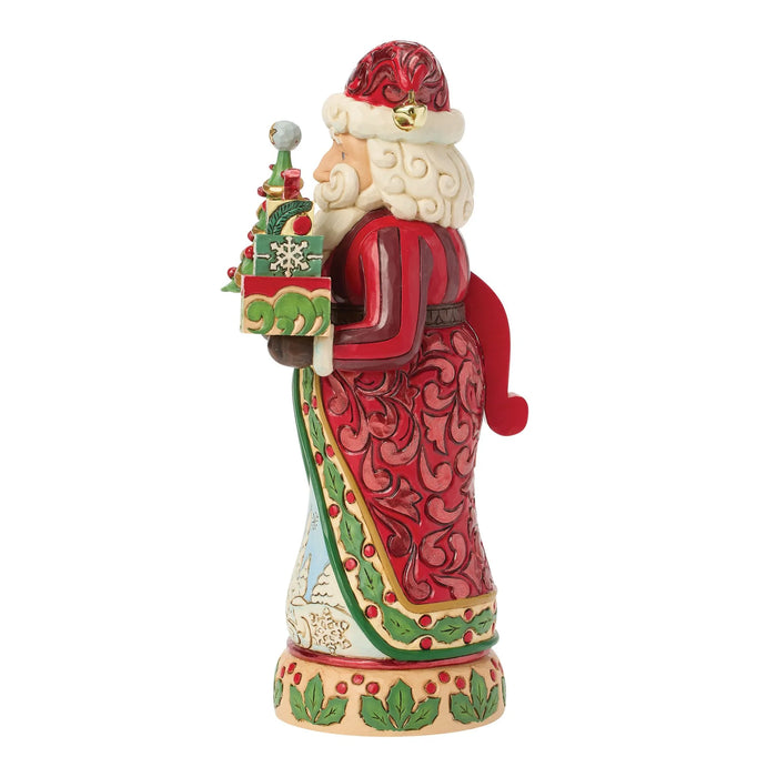 Festive Santa nutcracker figurine holding a Christmas tree and gifts on a white background