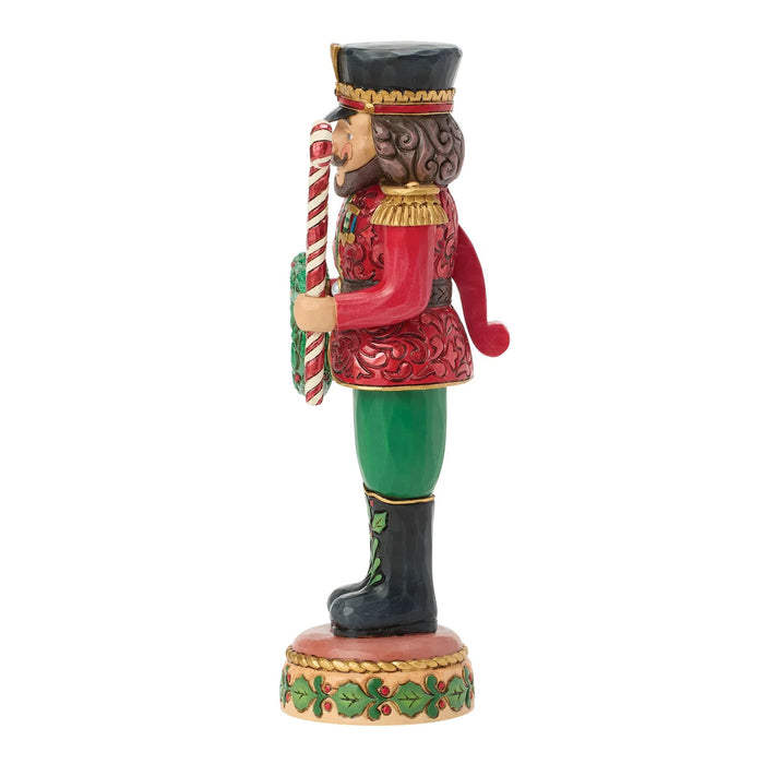 Decorative nutcracker figure holding a wreath and candy canes on a white background