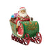 Figurine of Santa in a decorative sleigh with bags of gifts on a white background