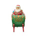 Figurine of Santa in a decorative sleigh with bags of gifts on a white background
